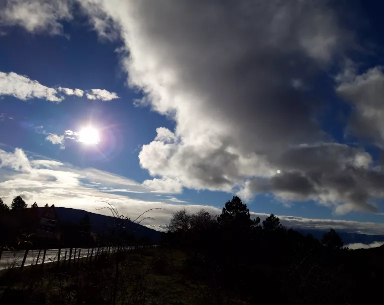 dunkle Wolken und grelle Sonne über Landschaft