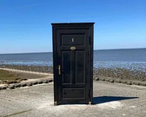 eine geschlossene Tür am Strand ohne Mauern oder Zaun drumherum
